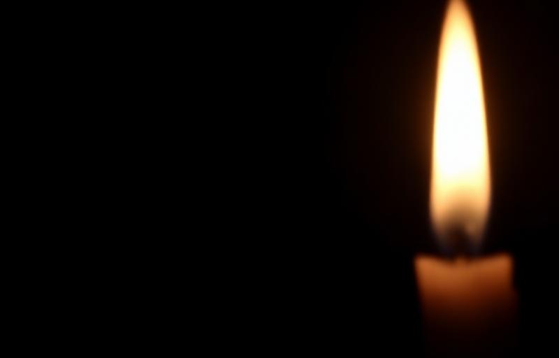 A candle flame in darkness representing quiet whisper levels